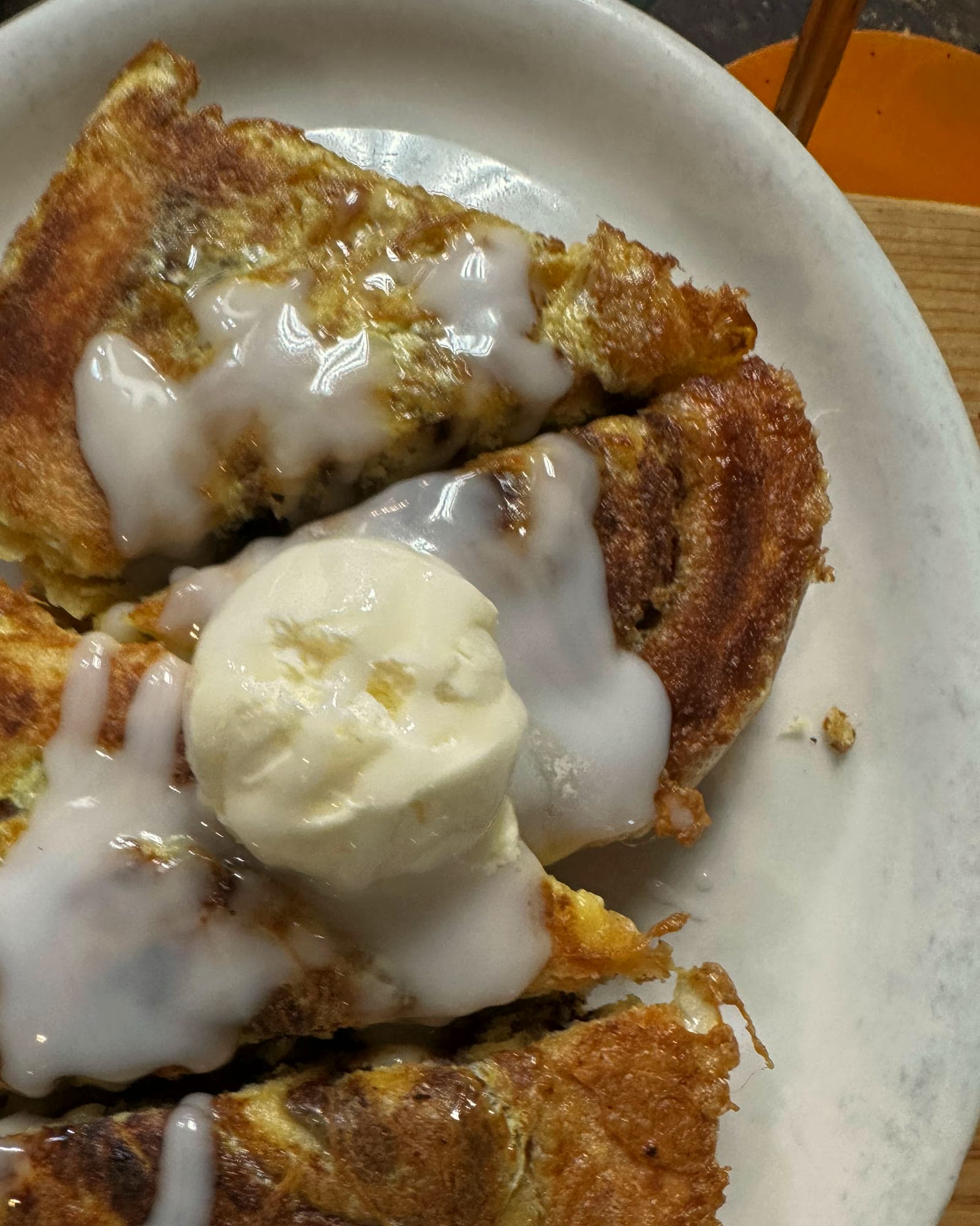 Cinnamon bun french toast with icing and a scoop of whipped butter